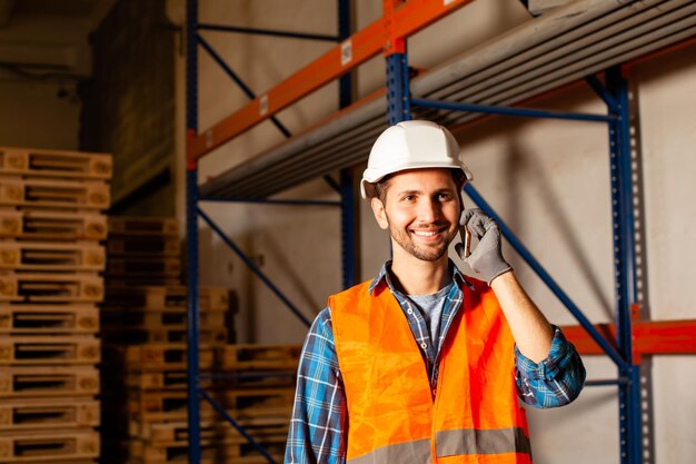 Der Arbeiter in Uniform steht neben den Regalen