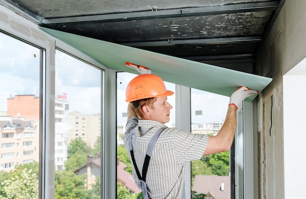 Der arbeiter installiert die trockenbauwand.