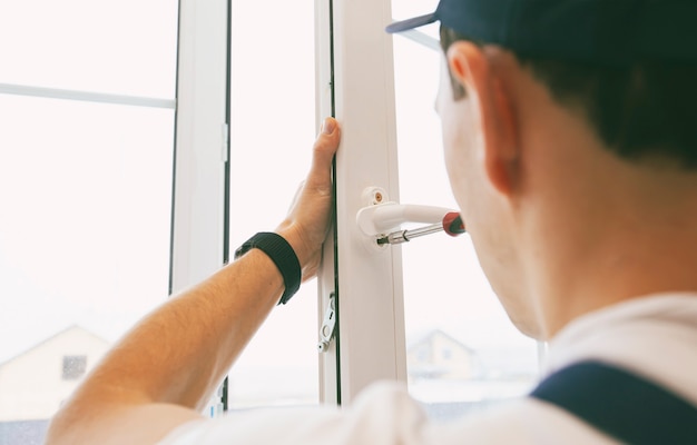 Der Arbeiter installiert und überprüft Fenster im Haus