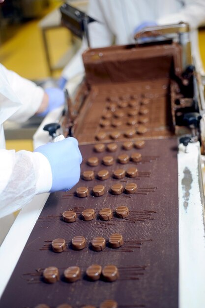 Foto der arbeiter schmückt die schokolade in der schokoladenfabrik photo_idcaptionschlüsselwörter schreien herunterladenurluserid