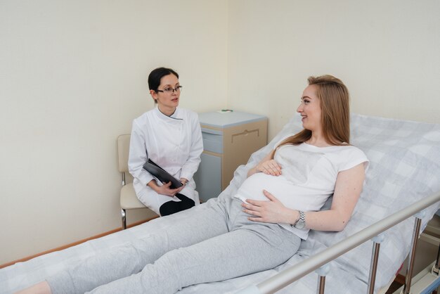 Der Arzt berät und betreut ein junges schwangeres Mädchen in einer medizinischen Klinik. Medizinische Untersuchung