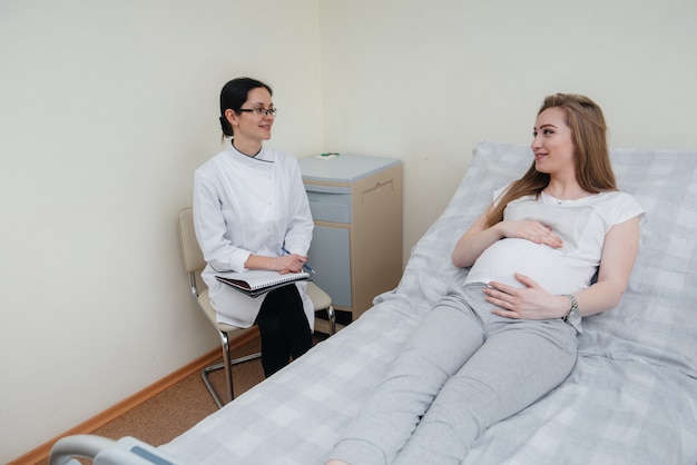 Der Arzt berät und betreut ein junges schwangeres Mädchen in einer medizinischen Klinik. Medizinische Untersuchung