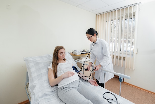 Der Arzt berät und betreut eine junge schwangere Frau in einer medizinischen Klinik. Ärztliche Untersuchung