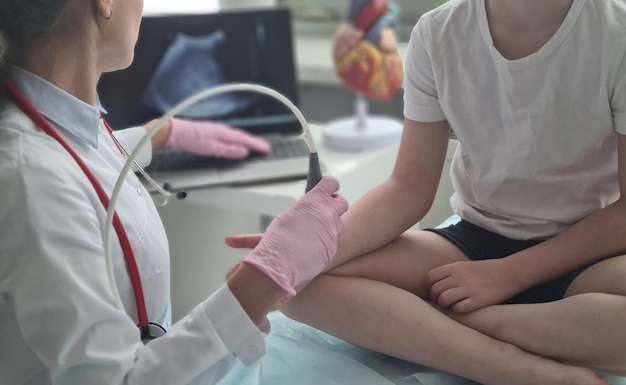Der Arzt führt eine Ultraschalluntersuchung des Handgelenks des Patienten durch Ultraschall der Handgelenke