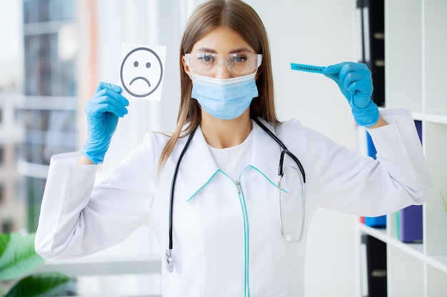 Der Arzt hält eine Karte mit dem Sad-Smile-Symbol im Büro der Klinik