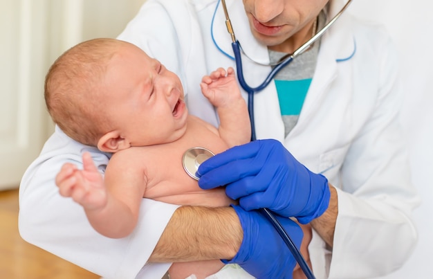 Der Arzt hört dem Baby mit einem Stethoskop zu