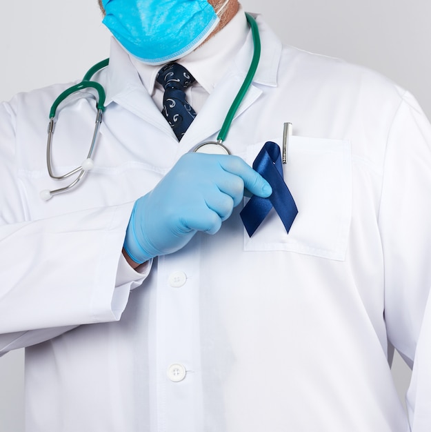 Der Arzt in weißer Uniform und sterilen Latexhandschuhen hält ein dunkelblaues Band