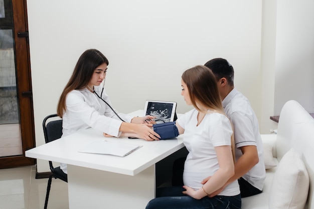 Der Arzt misst in der Klinik den Druck eines schwangeren Mädchens. Schwangerschaft und Gesundheitsvorsorge.