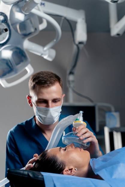 Der Arzt setzt auf der Intensivstation eine Maske zur künstlichen Beatmung der Lunge auf