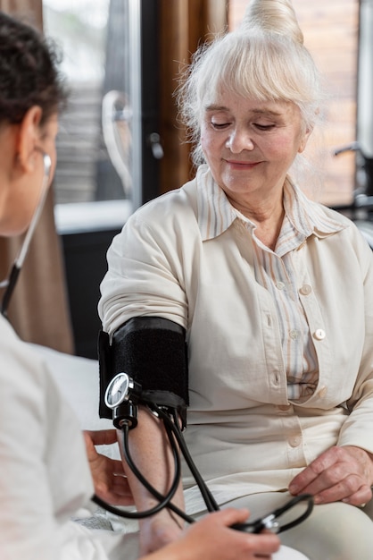 Der Arzt überprüft den Blutdruck ihrer Patientin