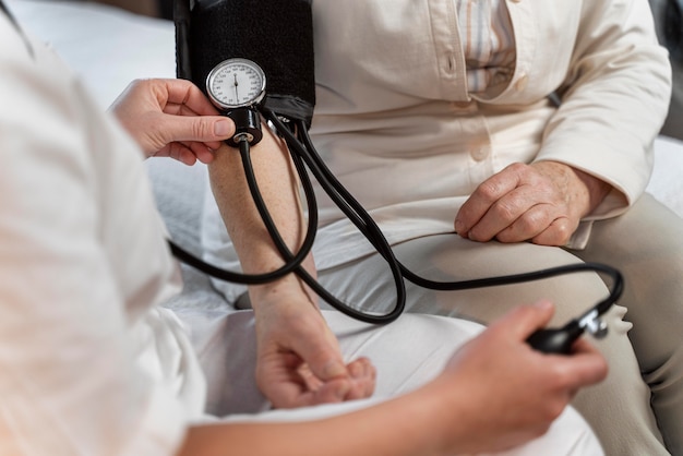 Foto der arzt überprüft den blutdruck ihrer patientin