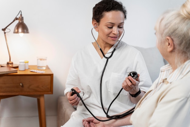 Foto der arzt überprüft den blutdruck ihrer patientin