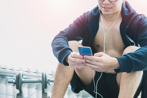 Der asiatische Athletenmann, der eine Jacke trägt, stehen still, nachdem er trainiert hat