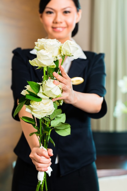 Der asiatische chinesische Hotelmanager heißt ankommende VIP-Gäste willkommen