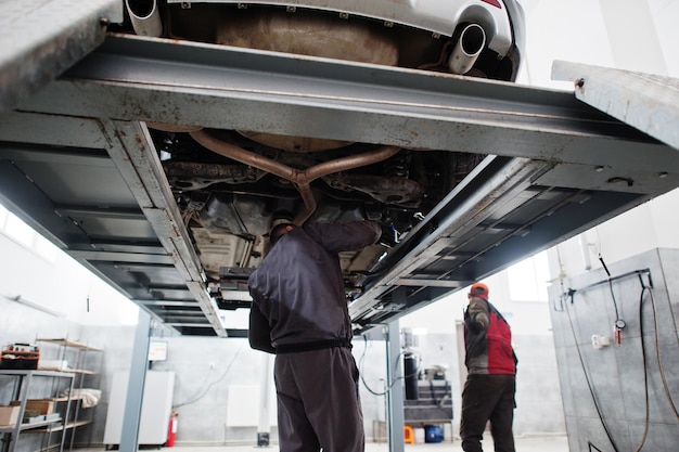 Der Automechaniker stellt ein amerikanisches SUV-Auto zur Diagnose und Konfiguration des Sturzes in die Werkstatt der Tankstelle