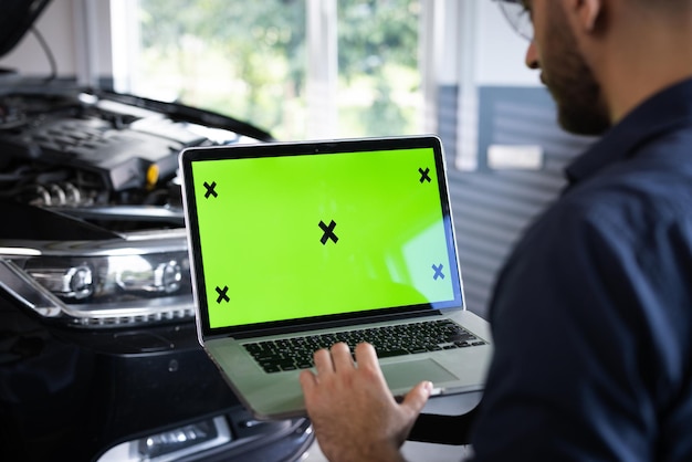 Der Autoservice-Mechaniker verwendet einen Laptop-Computer mit Green-Screen-Mock-up-Chroma-Key-Autodiagnose