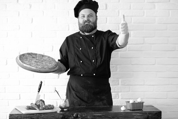 Der bärtige Chefkoch bereitet die Mahlzeiten am Tisch in der Küche zu