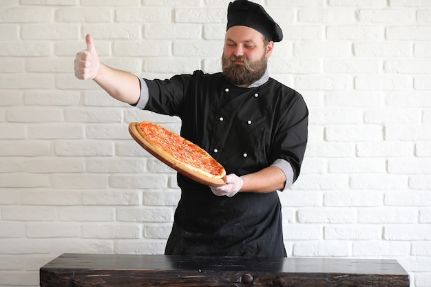 Der bärtige Chefkoch bereitet die Mahlzeiten am Tisch in der Küche zu