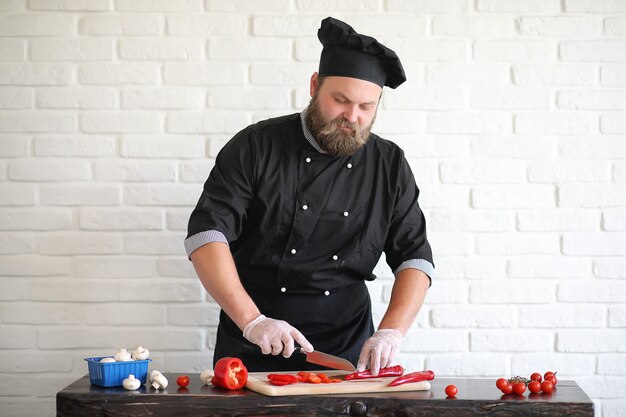 Der bärtige Chefkoch bereitet die Mahlzeiten am Tisch in der Küche zu