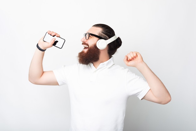 Der bärtige Hipster-Mann hat eine gute Zeit, während er der Musik zuhört.