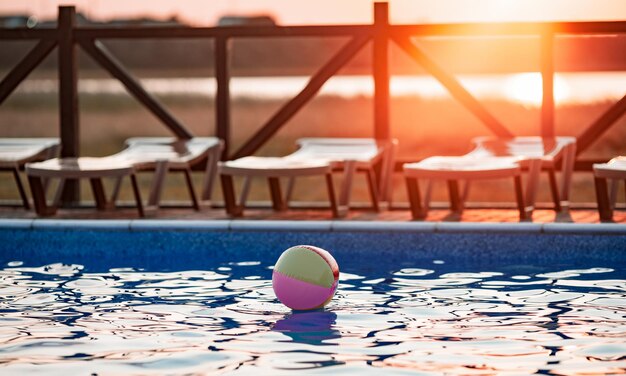 Der Ball schwimmt auf der Wasseroberfläche im Pool unter der Sommersonne