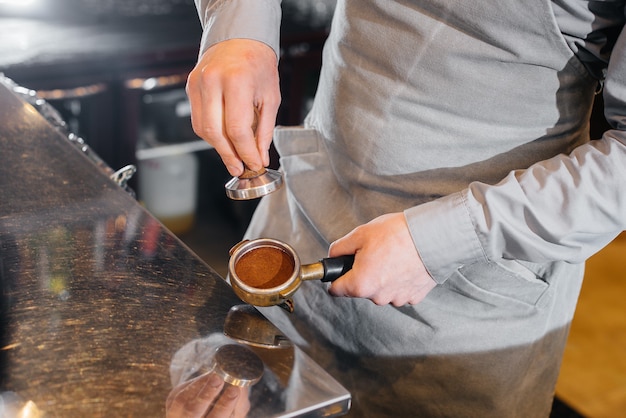 Der Barista bereitet köstlichen Kaffee in einer modernen Café-Nahaufnahme zu.