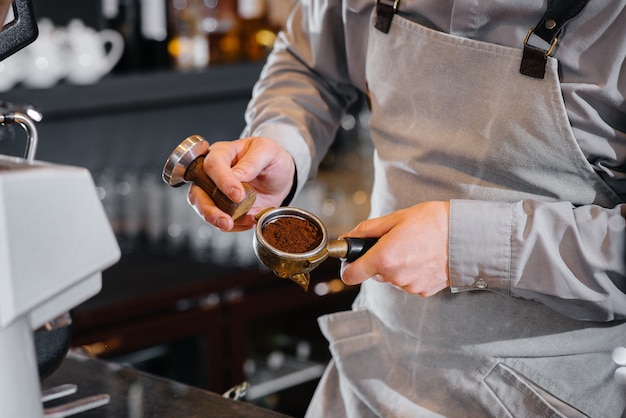 Der Barista bereitet köstlichen Kaffee in einer modernen Coffeeshop-Nahaufnahme zu.