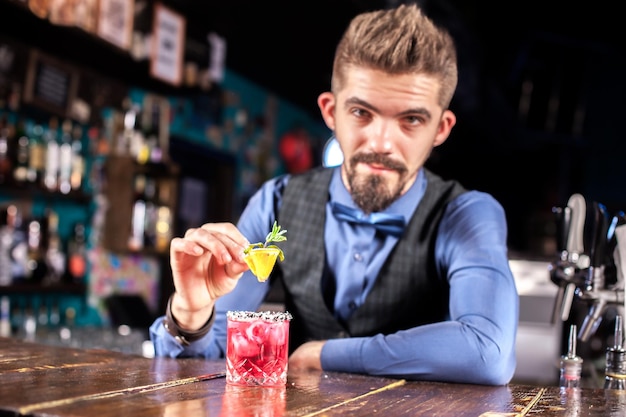 Der Barkeeper bereitet im Schankraum einen Cocktail zu