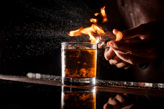 Der Barkeeper macht Flamme über Cocktail Nahaufnahme