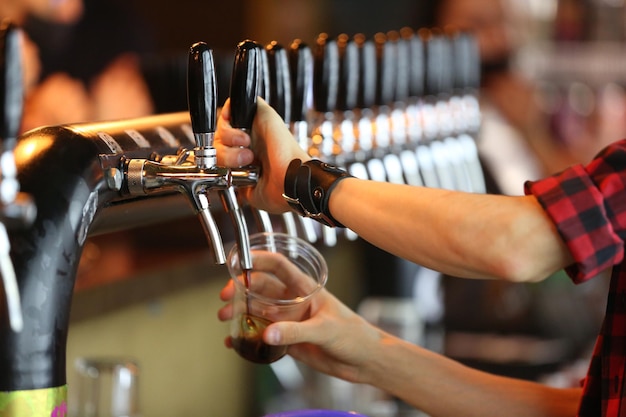 der Barkeeper schenkt Bier in der Bierbar ein