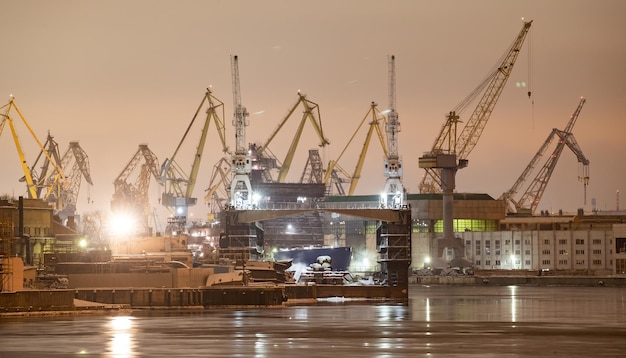 Der Bau nuklearer Eisbrecher bei Nachtkränen der baltischen Werft in einem frostigen Winter...
