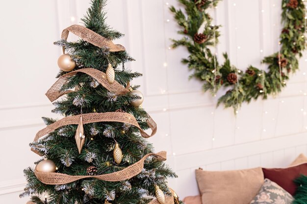 Der Baum ist mit bunten Spielzeugen und einer Girlande geschmückt. Nahaufnahmefoto in warmen Farben. Weihnachts- und Silvesterstimmung