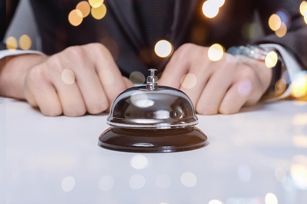 Der Bell-Service Geschäftsmann, der vor der Glocke am Tisch sitzt