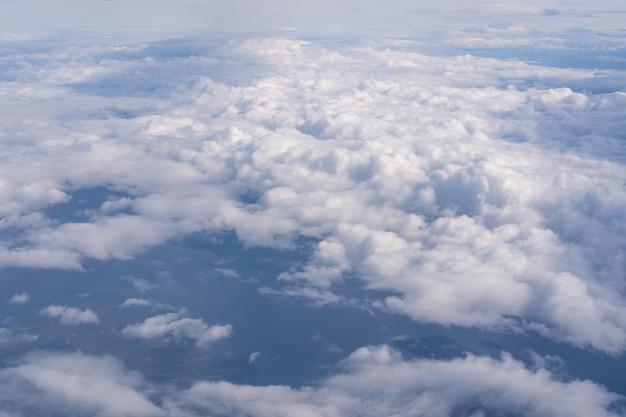 Der Blick aus dem Flugzeugfenster auf die Wolken und den Boden Die Landschaft der Erdoberfläche