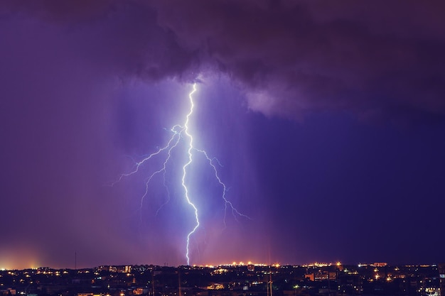 Der Blitz über dem Stadtbild in der Nacht