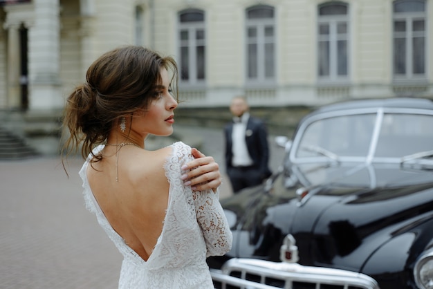 Der Bräutigam in einem grauen Anzug und die Braut in einem grauen Kleid sehen sich an