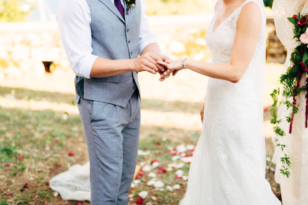 Der Bräutigam kleidet bei einer Hochzeit einen Ring am Finger der Braut