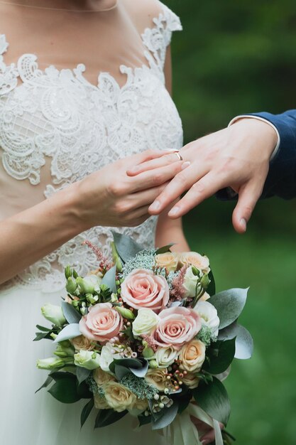 Der Bräutigam legt den Ring an die Hand der Braut Foto Nahaufnahme