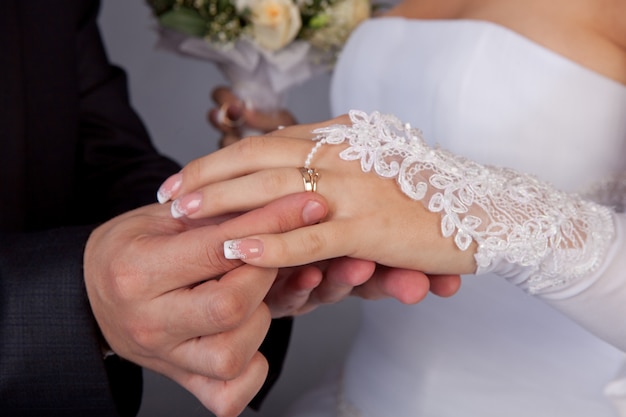 Der Bräutigam legt der Braut einen Ring an die Hand