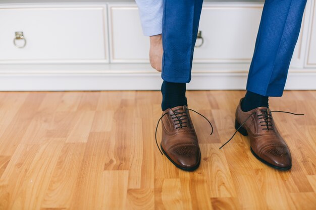 Der Bräutigam sitzt Schuhe am Hochzeitstag.