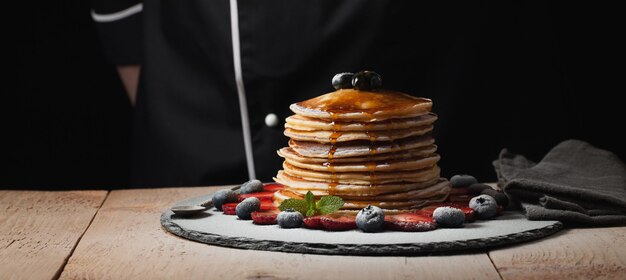 Der Chef bereitet Pfannkuchen mit Beeren zu.