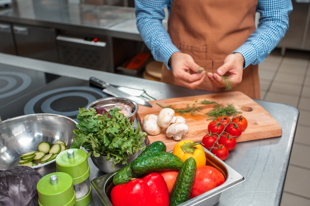 Der Chef im braunen Schutzblech kochend in einer Restaurantküche