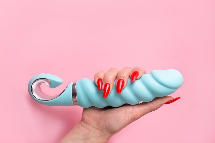 Foto der dildo in der hand auf einer rosa wand, sexspielzeug