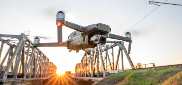 Der Einsatz von Drohnen in der Industrie. Die Drohne inspiziert die Eisenbahnbrücke im Morgengrauen.
