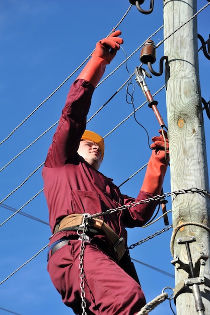 Der Elektriker installiert die Erdung an der Stromleitung, bevor er sie repariert