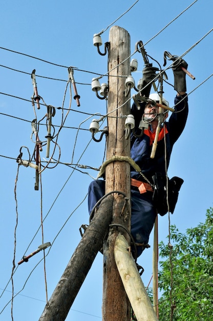 Der Elektriker-Lineman-Reparaturarbeiter installiert die Erdung an der Stromleitung, bevor er sie repariert.