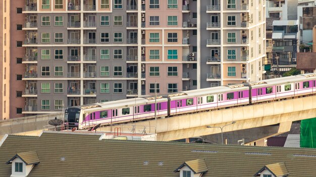 Der elektrische skytrain fährt durch die stadt, gebäude und häuser.