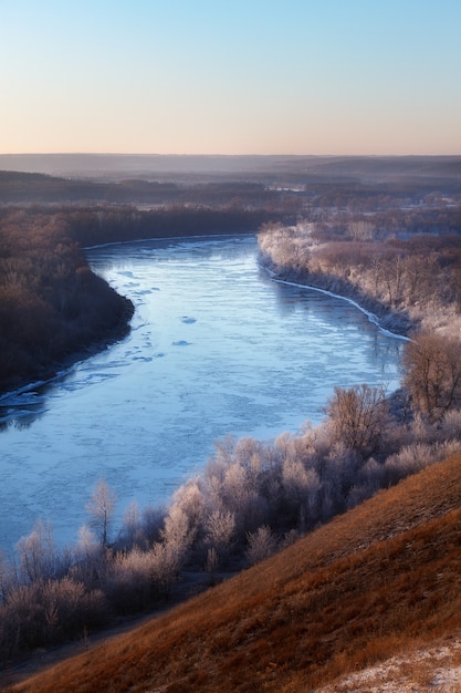 Der erste Frost am Fluss im Herbst. Die Bäume am Ufer sind mit Raureif bedeckt.