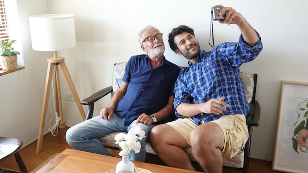 Der erwachsene Hipster-Sohn und der alte Senior-Vater bleiben für die Arbeit zu Hause. Zwei Generationen haben einen Bart, reden miteinander und entspannen sich mit einem Lächeln