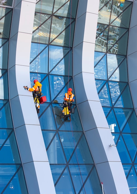 Der Fensterputzer arbeitet an einem modernen Wolkenkratzer mit Glasfassade